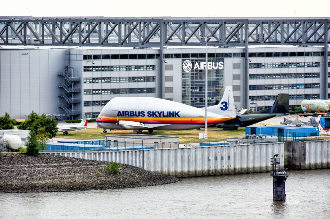 Exterior view of the Airbus factory in Hamburg-Finkenwerder. Aircrafts are parked in front of the building.